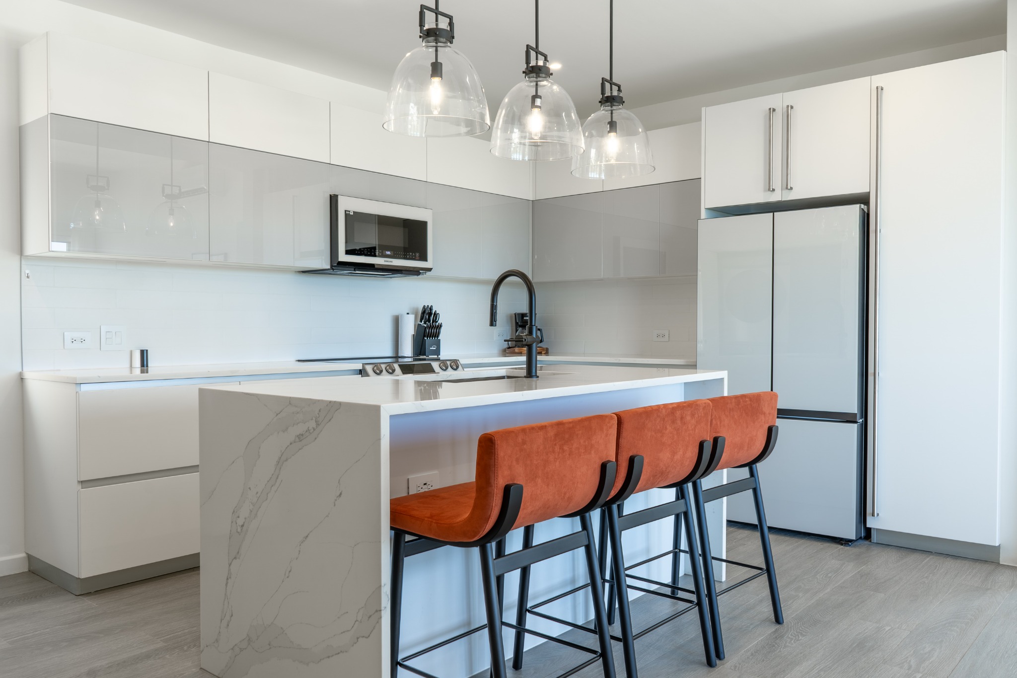 Designer kitchen with marble island and pendant lights