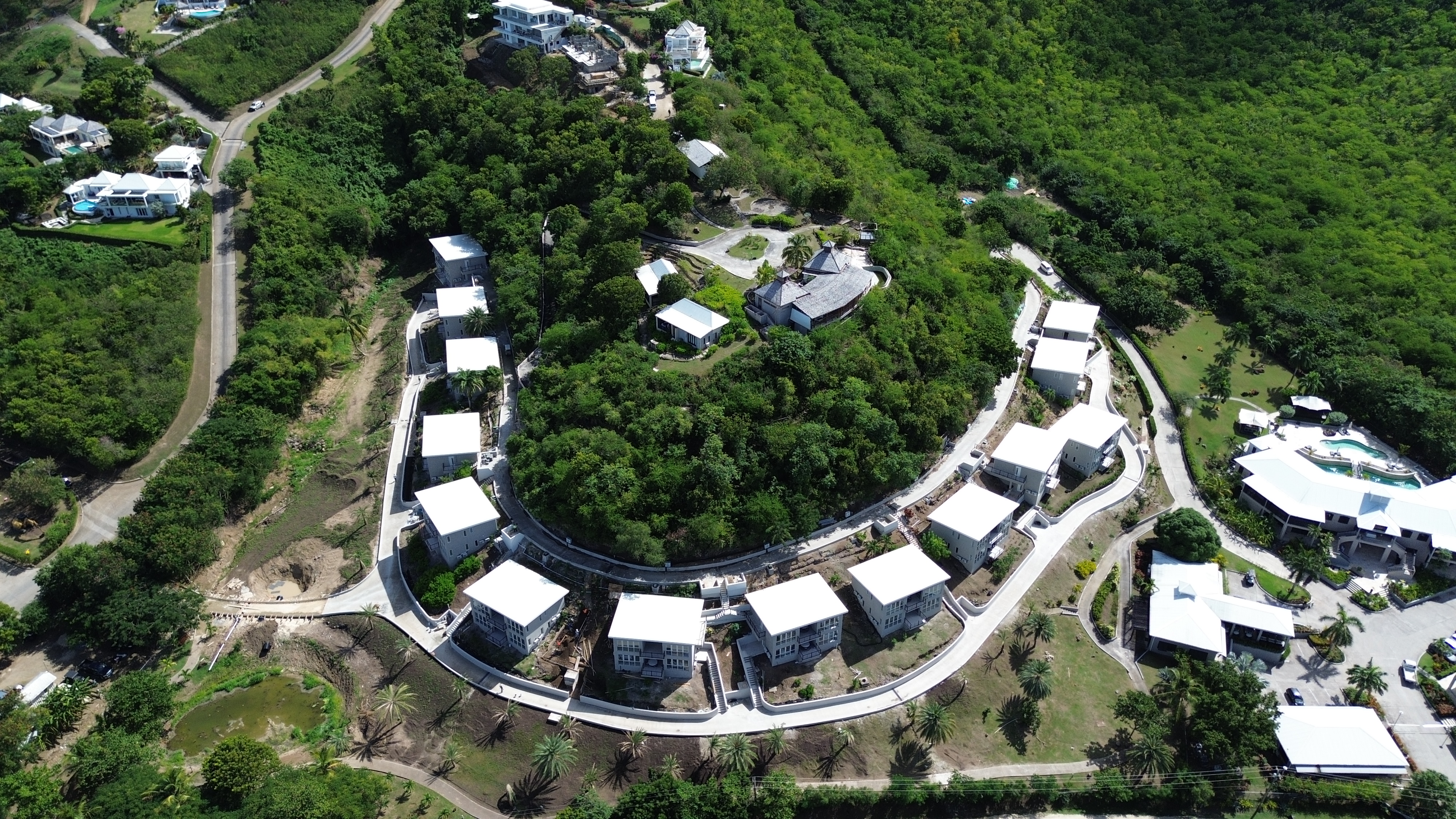 Aerial view of Sugar Ridge Condos showing 14 luxury 2-bedroom residences arranged around a private wooded interior in Jolly Harbour, Antigua